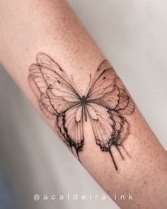 a black and white butterfly tattoo on the arm