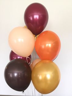 a bunch of balloons sitting on top of each other in front of a white wall