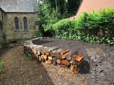 a pile of logs sitting in front of a building