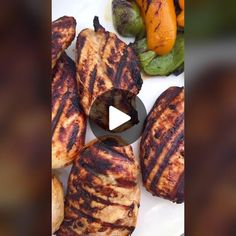 grilled meats and vegetables on a plate with a video player in the middle