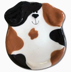 a brown and white dog with black spots on it's face is sitting in front of a white background