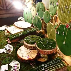 a table topped with lots of green plants and wooden slices covered in mossy material