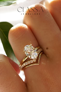 a close up of a person's hand with a diamond ring on their finger