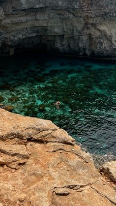 the water is crystal clear and green in this cave area with rocks on both sides