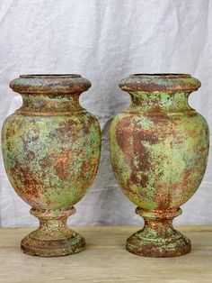 two green vases sitting on top of a wooden table