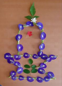 purple flowers and green leaves are arranged in the shape of a woman's head