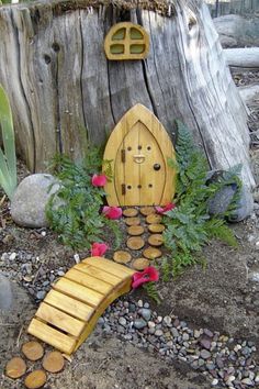 a wooden fairy house sitting on top of a pile of rocks