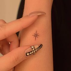 a woman's arm with a star tattoo on it