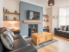 a living room filled with furniture and a flat screen tv mounted on the wall above a fire place