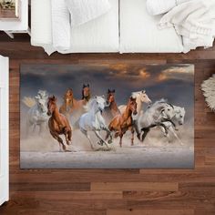 four horses running in the desert on a bed with white linens and wooden headboard