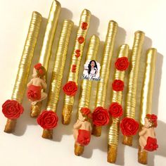 there are many gold sticks with red roses on them