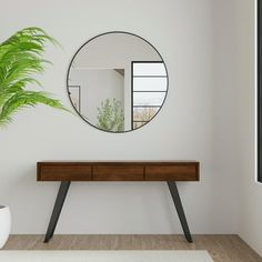 a mirror on the wall above a table with a potted plant