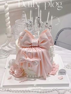 a cake decorated with pink bows and pearls