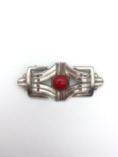 A modernist inspired Art Deco brooch made from two art deco stampings that were produced in an old factory in Paris that closed down several years ago.The brooch is set with an Opaque red glass stoneIt is made from solid brass which has been 5 micron silver plated and has a high quality pin on the reverse with a roll type safety catch. Retro Red Brooch Jewelry, Red Retro Brooch Jewelry, Art Nouveau Necklaces, Art Deco Brooch, Old Factory, Dog Brooch, Scottie Dog, Red Glass, Solid Brass