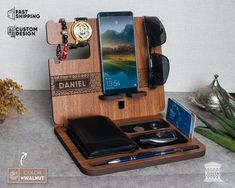 a cell phone, wallet, and other items are arranged on a wooden desk organizer