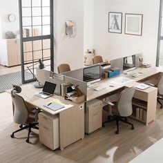 an office area with desks, chairs and computers