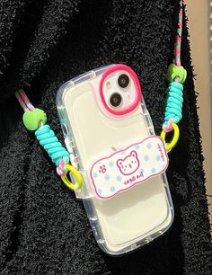 an iphone case with a bear on it and some beads attached to the phone holder