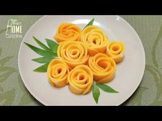 some food is on a white plate with green leafy stems and leaves around it