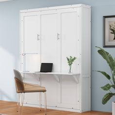 a white cabinet sitting next to a desk with a laptop computer on top of it