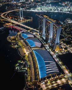 an aerial view of a city at night with lots of lights in the buildings and water