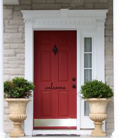 a red front door with two planters on either side