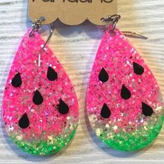 pink and green watermelon earrings with black dots on them, sitting on top of a