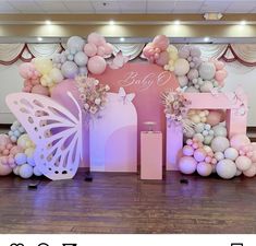 a pink and white balloon arch with balloons