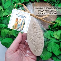 a hand holding a soap shaped like a shoe with a tag attached to the front