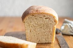 a loaf of bread sitting on top of a wooden cutting board next to a knife