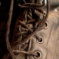 an old pair of brown boots that have been covered with some kind of rope and thread