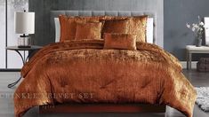 a bed with orange comforter and pillows in a room