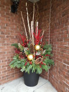 a planter filled with pine cones and other holiday decorations