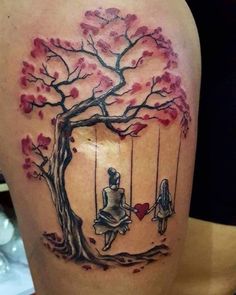 a woman sitting on a swing in front of a tree with red leaves and a heart