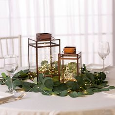 the table is set with candles and greenery