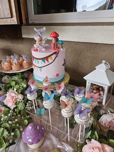 a table topped with lots of cake and cupcakes