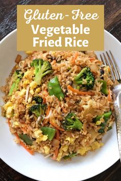 a white plate topped with fried rice and veggies next to a silver fork