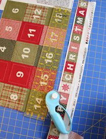 a pair of scissors sitting on top of a piece of fabric next to a ruler