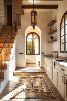 a kitchen with an area rug on the floor and stairs leading up to the second floor