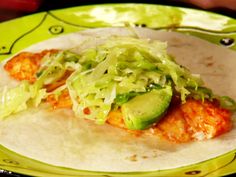 a tortilla filled with meat, lettuce and sauce on a plate