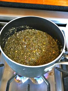 a pot filled with green tea sitting on top of a stove