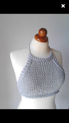 a white mannequin wearing a gray knitted halter top with wooden buttons