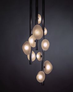 a chandelier with several balls hanging from it's black metal rods and lights