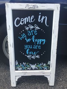 a chalkboard sign that says come in we are so happy you are here