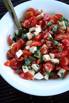 a white bowl filled with tomatoes and tofu