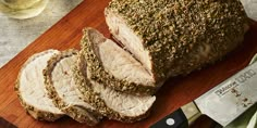 sliced pork on cutting board with knife and glass of wine