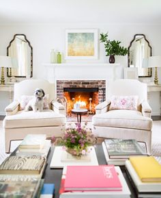 a living room filled with furniture and a fire place in the middle of the room