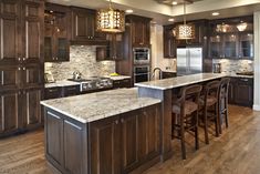 a large kitchen with wooden cabinets and marble counter tops