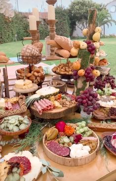 a table filled with lots of different types of food on top of wooden trays