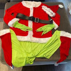 a santa clause outfit is laying on top of a couch with his hands in the pockets