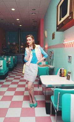 a woman standing in a diner with her hands on her hips